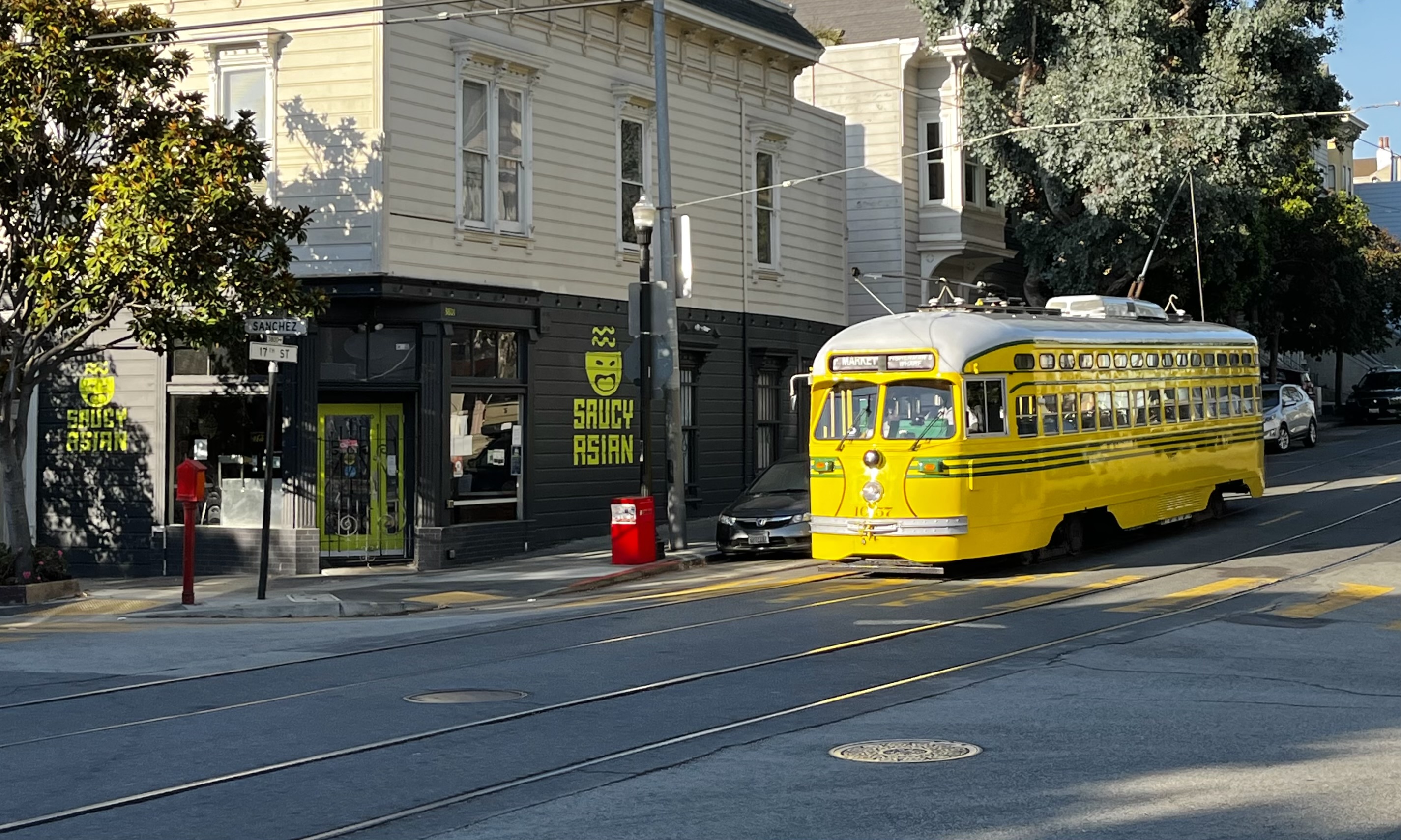 Muni streetcar no. 1057 passing by Saucy Asian on 17th Street at Sanchez Street.